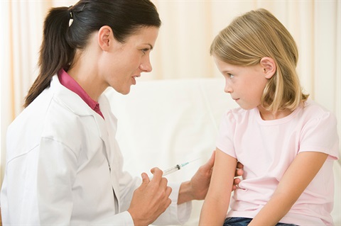 doctor giving shot to young girl