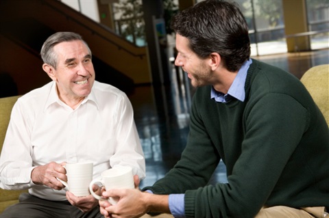 Older man  having coffee with younger man