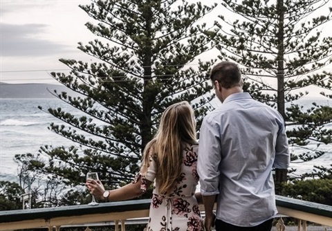 Couple standing on a balcony in Lorne overlooking water
