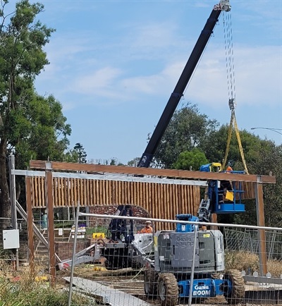 people using a crane to assemble a structure.