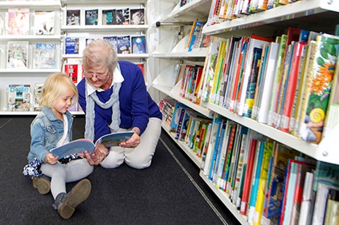 small child reading with nan