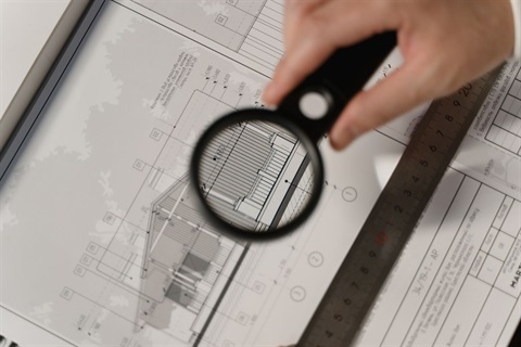 magnifying glass over building plans