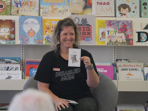 Renee d'Offay showing children an Auslan flashcard from the book 'A Visit to the Zoo'. 